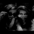 A grayscale animated icon shows a figure with long dark hair covering their face, then lowering hands to reveal a smiling expression against a black background.
