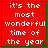 Red square with green border displaying white text 'it's the most wonderful time of the year' and small green pixelated tree in bottom-right corner.
