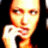 Pixelated close-up of a person holding a microphone, with warm orange and red tones dominating the image against a dark background.
