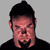 Static pixelated icon of a person with short dark hair and facial features against a gray background, wearing a black top.