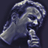 Pixelated image of a person with light hair holding a microphone, next to text about a new album release.
