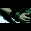 A hand gripping a guitar neck with a studded wristband, shown in six with subtle hand position shifts