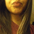 A person with long brown hair and a maroon top appears in four showing subtle facial expression changes