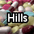 A four- of pills with overlaid text reading Hills, Takes, Pills against a background of assorted colorful capsules