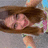 Pixelated image of a person with brown hair lying down, wearing light-colored clothing against a dark background.