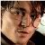 Pixelated close-up of a person's face with light skin tone, dark hair, and dark clothing visible at the bottom edge.