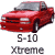 Pixelated red pickup truck with gray roof and black accents, positioned at a three-quarter angle on light gray background.