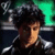 Static 50x50 pixel icon showing a person with dark hair and light skin in profile, wearing metallic armor-like shoulder pieces against a green and black background.