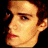 identical pixelated head portraits with brown hair, blue eyes, and red lips against a black background