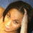 A pixelated close-up of a person with dark hair, light skin tone, and closed eyes resting against a hand, set against warm-toned background.