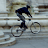 Animated sequence of a person riding a bicycle in front of stone architectural , showing motion progression from left to right