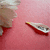 A pink background with a partial figure on the left and a small boat-like object in the center, transitioning from visible to partially obscured.
