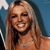A pixelated close-up of a smiling person with long light brown hair, wearing a light blue necklace against a blue background.
