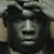 Static 50x50 pixel icon showing a low-resolution grayscale close-up of a person's face with dark hair and neutral expression, rendered in blocky pixels with visible dithering.