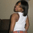 Pixelated image of a person with dark hair wearing a white sleeveless top and orange pants, standing against a neutral background.