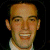 A pixelated image of a person with short dark hair and light skin wearing a white shirt, next to green text reading 'Original Icons .com' on a solid background.