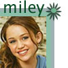 A static icon featuring a person with light brown hair and blue eyes, wearing a blue top, with the text 'miley' above and a green starburst symbol to the right.