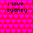 Pixelated red background with repeating pink heart pattern and black text "i love sydney" in four quadrants.