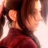 A close-up profile view of a person with brown hair tied in a ponytail, wearing a maroon top, against a bright background.