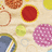 Pixelated static image of multiple circular icons on a light beige background with no visible text or motion.