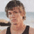 A pixelated image of a person with short brown hair wearing a black tank top, positioned next to green text on a dark background.