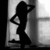 Black-and-white silhouette of a woman in a dress with hands behind head, standing against window-like background; text "50000" and "sexiiii" overlaid.