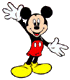 Mickey Mouse in red shorts and yellow shoes waves with one hand while the other is extended, standing against a gray background.