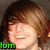 Pixelated close-up of a smiling person with brown hair, green text reading 'lom' at bottom left.