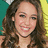 A static image with a yellow background, featuring a photo of a smiling woman with long brown hair on the left and pink pixelated text on the right.