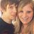 Two people pose closely together, one with short brown hair in a dark shirt and the other with long light brown hair smiling broadly.