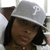 A pixelated static image shows a person with dark hair wearing a light gray cowboy hat, viewed from the side against a plain background.