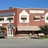 A pixelated static image shows a building facade with brown and white sections, multiple windows, and a blue sky background.
