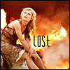 A woman in a brown patterned dress sits with knees drawn up against a fiery orange and red background, the word 'LOST' overlaid in black text.