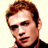 Pixelated static image of a person's head and shoulders with brown hair, light skin tone, and dark clothing against a plain background.