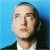 A split-frame contact sheet showing a pixelated portrait on the left and green text logo on the right against blue and dark green backgrounds.