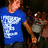 A person in a blue T-shirt with white text stands next to an animal figure, shown across where the right arm position shifts slightly