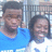 Two people stand side-by-side; the person on the left wears a blue shirt, the person on the right wears a white shirt with a blue design. The person on the right smiles in some frames.