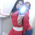 Two people in red outfits embrace, one holding a bright light source near their faces against a plain background.