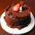 Pixelated image of a chocolate cake with a strawberry on top, a cartoon character with blonde hair sticking out its tongue, a brown stick figure with a pink tongue, and red text reading "mmmmm... back off my chocolate :()".