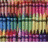 Pixelated image of colorful crayons behind a black metal fence with mirrored text on a white background.