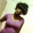 Pixelated image of a person with dark curly hair wearing a purple sleeveless top, viewed from the side against a light background.