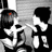 Black-and-white pixelated image of two figures in a dynamic pose with red text overlay reading "1, 2, 3, 4. Tell me That you Love me More" and additional fragmented lyrics below.