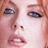 Pixelated close-up of a person's face showing eyes, nose, and mouth with visible dithering and color blending on a light background.