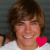 A pixelated image of a person with brown hair wearing a white shirt, featuring a red heart symbol over the chest area.
