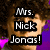 A pixelated image of a person with curly brown hair and purple clothing, overlaid with bold black text reading "Mrs. Nick Jonas!" in three stacked lines.