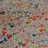 A static pixelated image with no discernible subjects or text, composed of multicolored square pixels in shades of brown, green, red, blue, and gray.