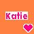 Pixelated orange background with a rectangular nameplate displaying 'Katie' in pink and purple gradient letters, and a pink heart icon below it.