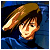 Pixelated character with brown hair and blue clothing against a dark blue background, rendered in a retro 8-bit style.