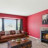 A pixelated static image showing a blurred interior with red structural elements, windows, and furniture under soft lighting.