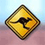 Yellow diamond-shaped warning sign with black curved arrow symbol on a light blue and pink gradient background.
